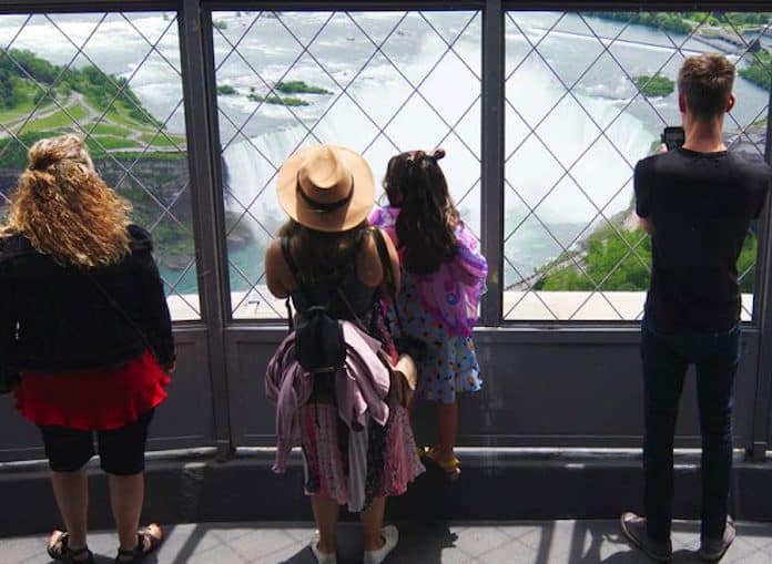 Tourists looking out at Niagara Falls from the observation deck of the Skylon Tower