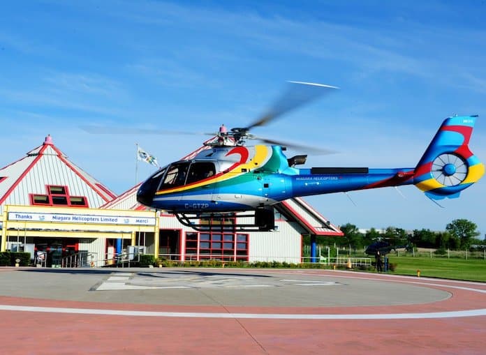 multi-coloured helicopter hovering above the helipad at Niagara Helicopters