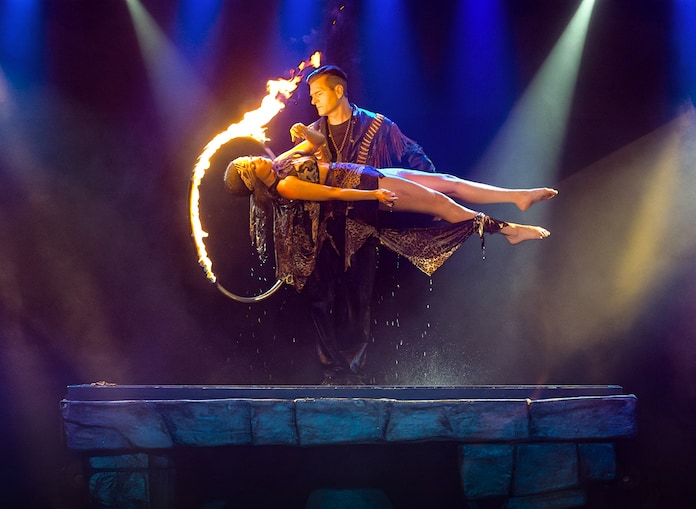 Magician Greg Frewin passing a ring of fire over a levitating woman